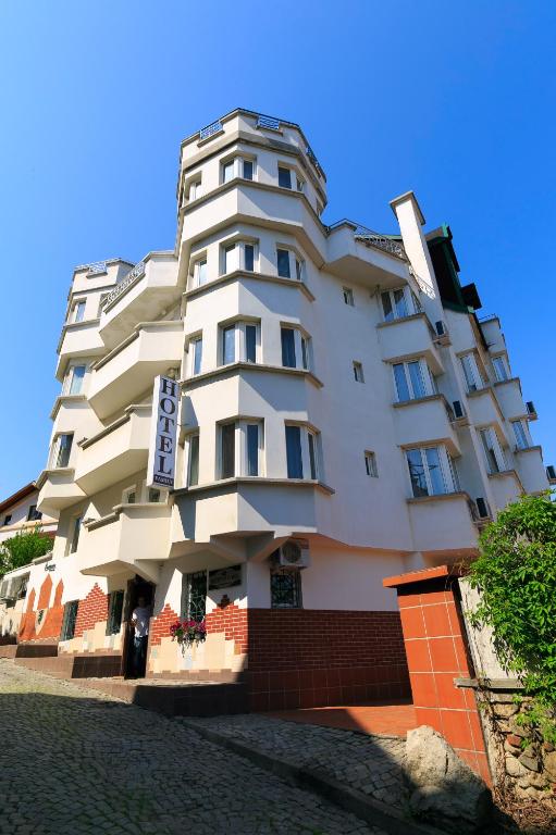 Un edificio alto y blanco con un cartel. en HOTEL THE WHITE HOUSE Plovdiv, en Plovdiv