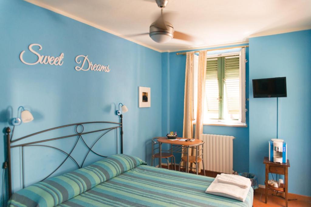 - une chambre avec un lit et un mur bleu dans l'établissement Al Cardinale Rooms & Studios, à Lucques