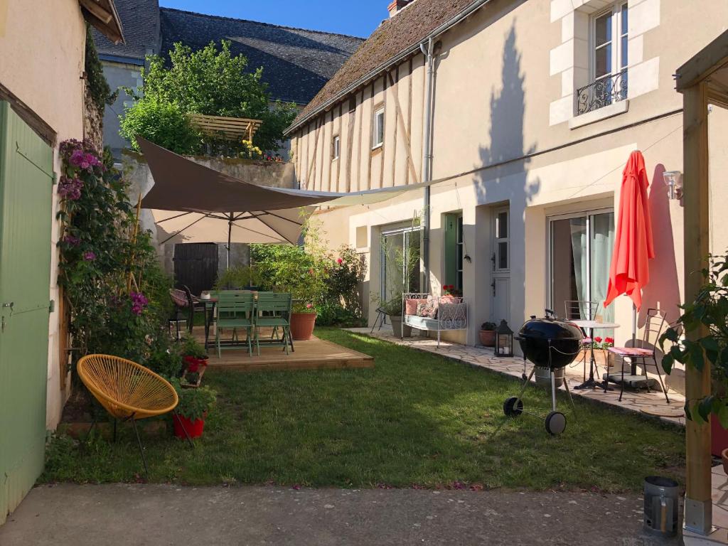 a backyard with a grill and a house at Les 3 échoppes in Chargé