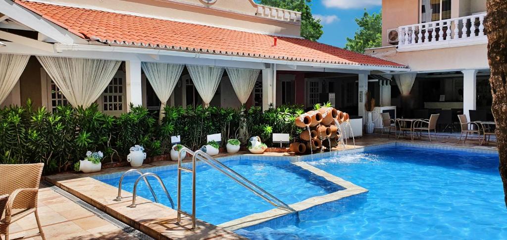 a swimming pool in front of a house at Hotel Villa Mayor Charme - fortaleza in Fortaleza