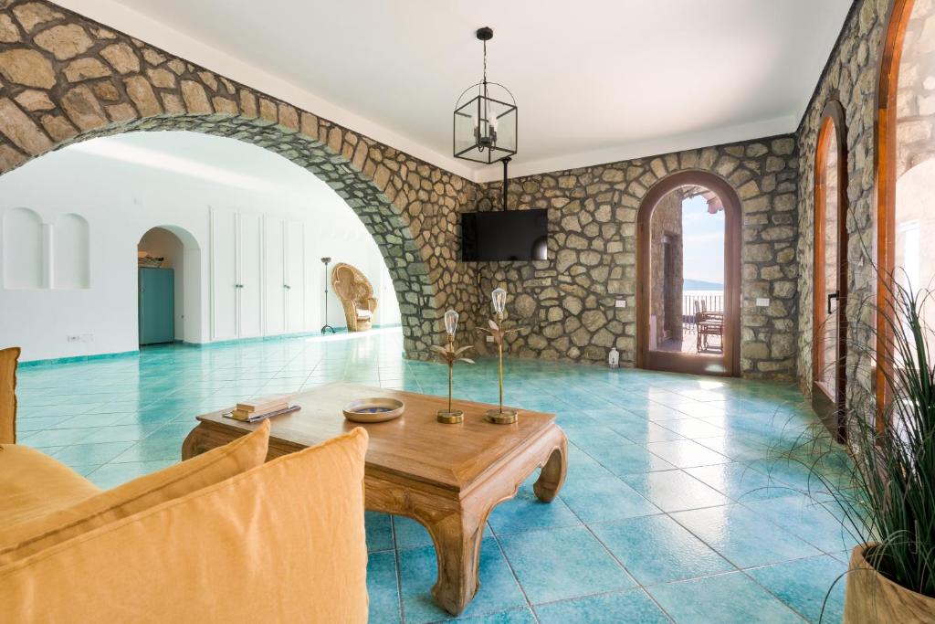 a living room with a table and a stone wall at La Torre del Vervece in Massa Lubrense
