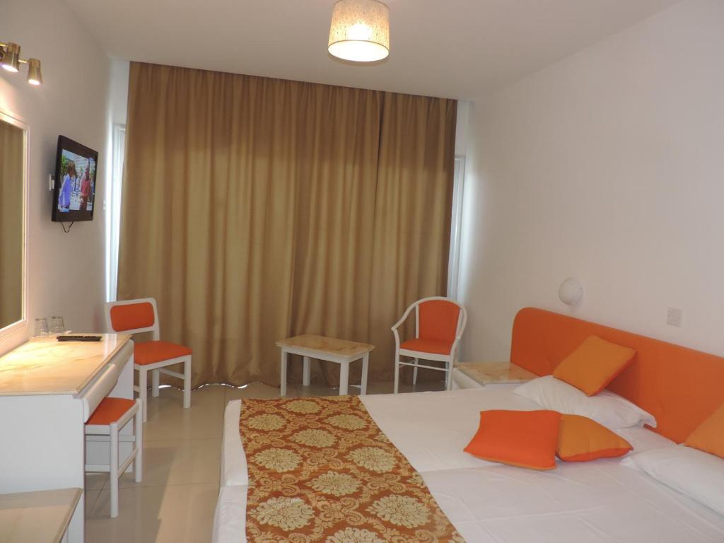 a hotel room with a bed and a table and chairs at Corfu Hotel in Ayia Napa