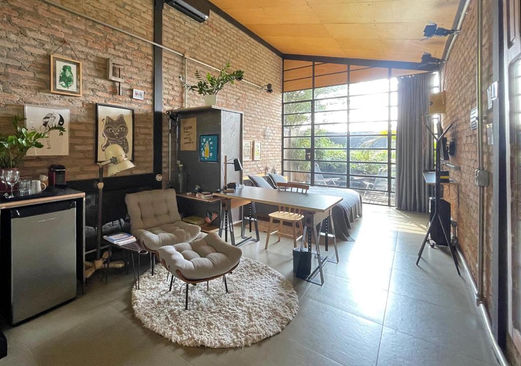 een woonkamer met een tafel en stoelen en een eetkamer bij Degar Studios in Sao Paulo