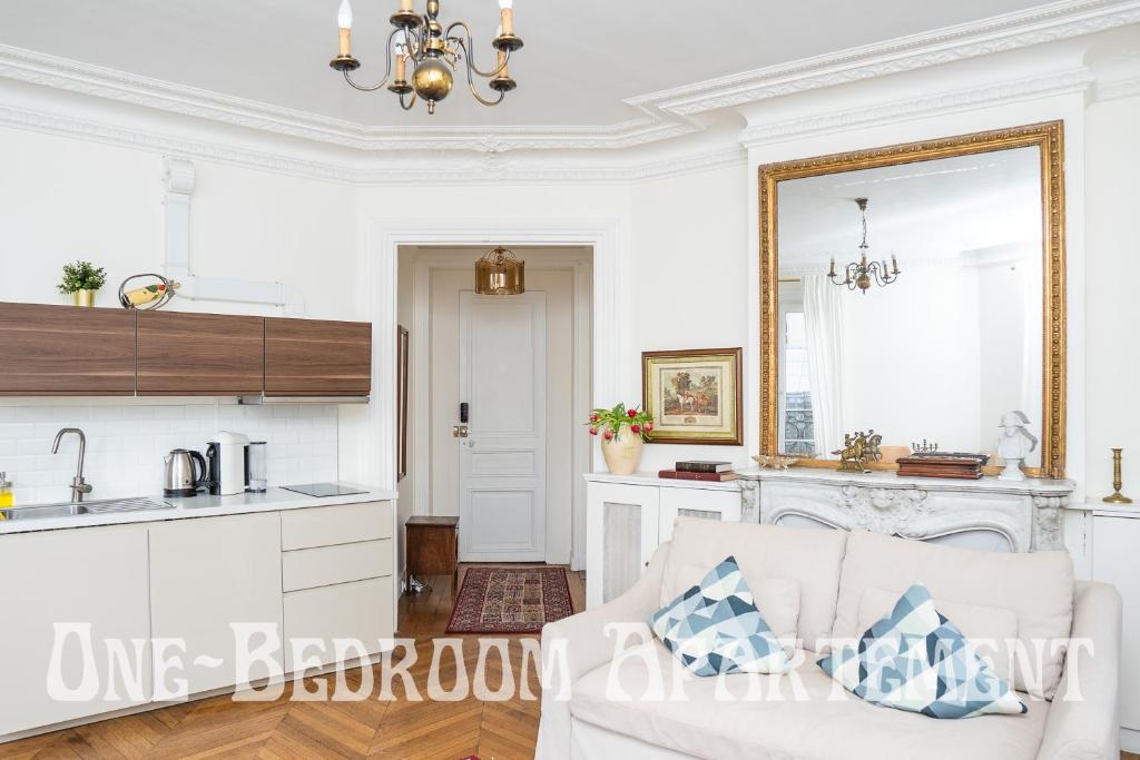 un soggiorno con divano e una cucina di Eiffel Tower view Residence a Parigi