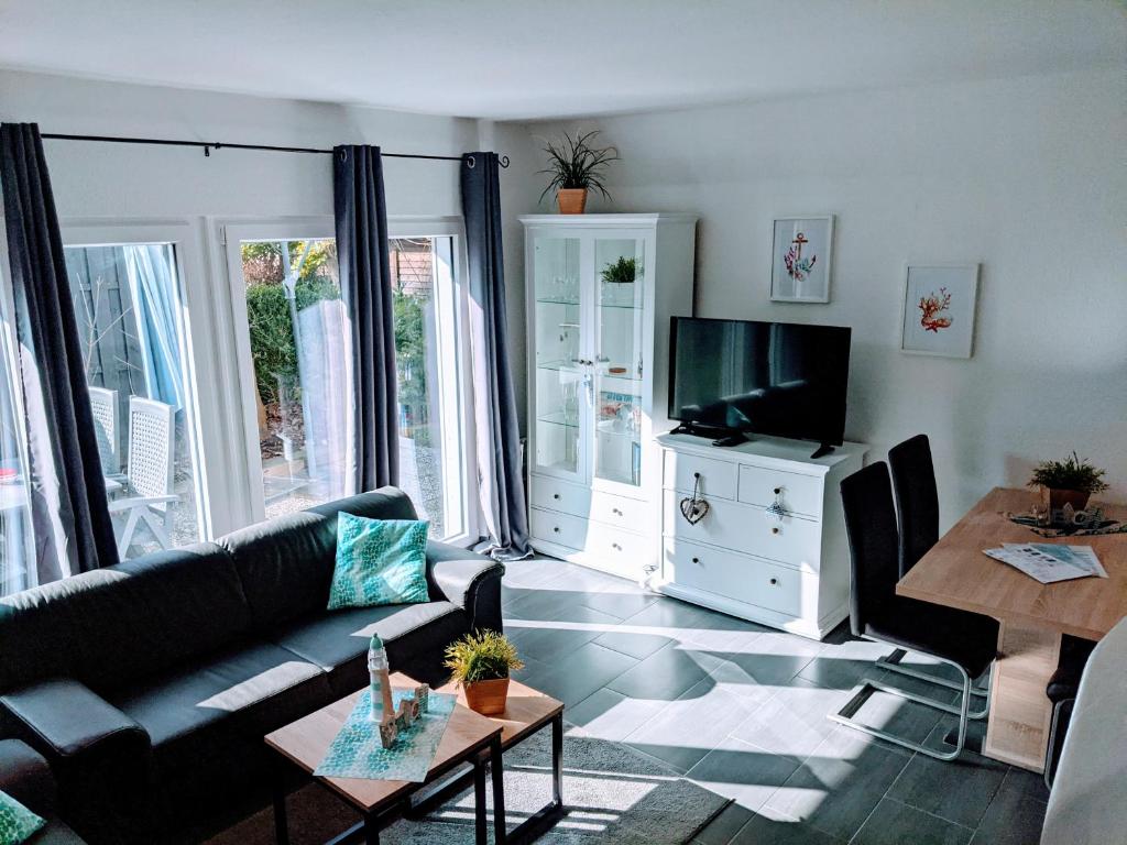 uma sala de estar com um sofá e uma televisão em Dat lütte Strandhuus em Cuxhaven
