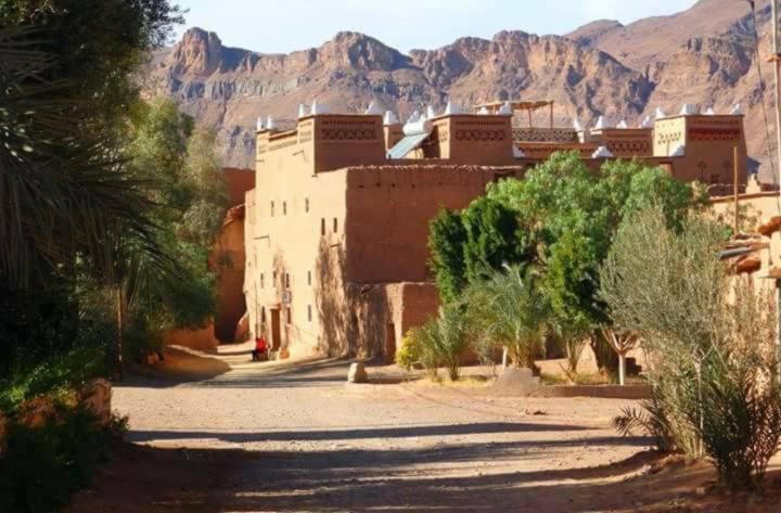 a building in the desert with mountains in the background at kasbah timidarte in Zaouïta Bou Lhâssane