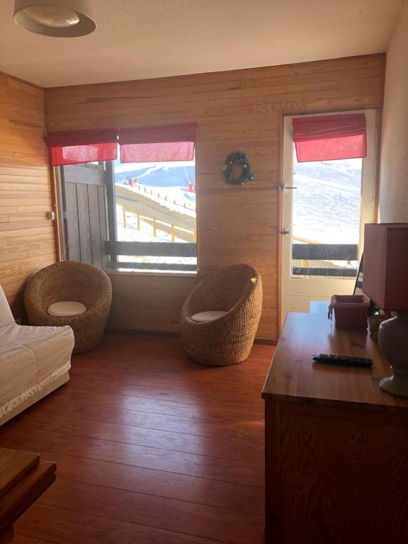 a room with two chairs and a bedroom with a beach at PRINCESSE DES NEIGES in Saint-Aventin