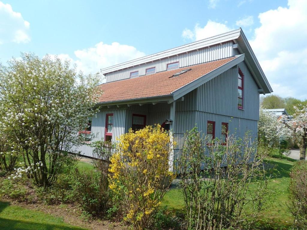 a green house with a red roof at Ferienhaus Nr 10B2, Feriendorf Hagbügerl, Bayr Wald in Waldmünchen