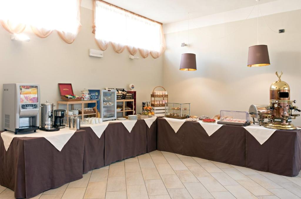 a long table in a large room with a table sidx sidx at Hotel Spinelli in Viareggio