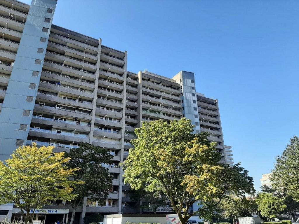 a tall apartment building with trees in front of it at Apartment with balcony near D sseldorf in Neuss