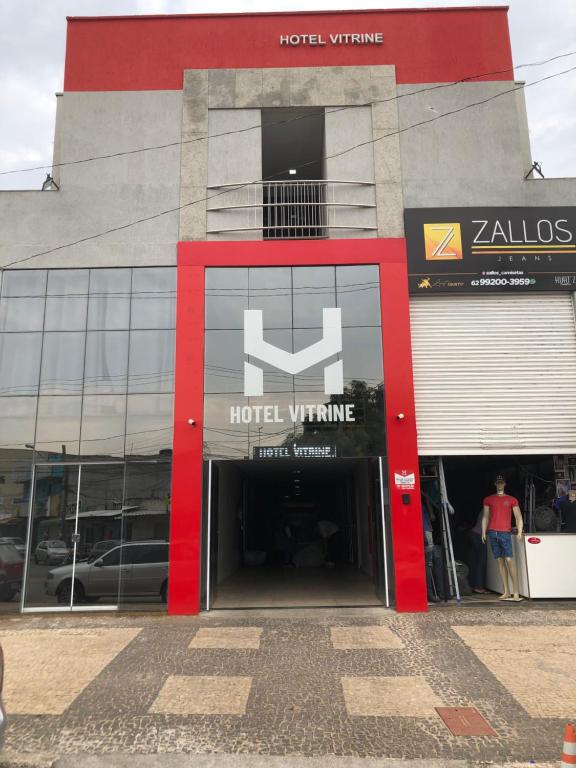 un bâtiment d'hôtel avec une porte rouge et un panneau d'hôtel dans l'établissement Hotel Vitrine, à Goiânia