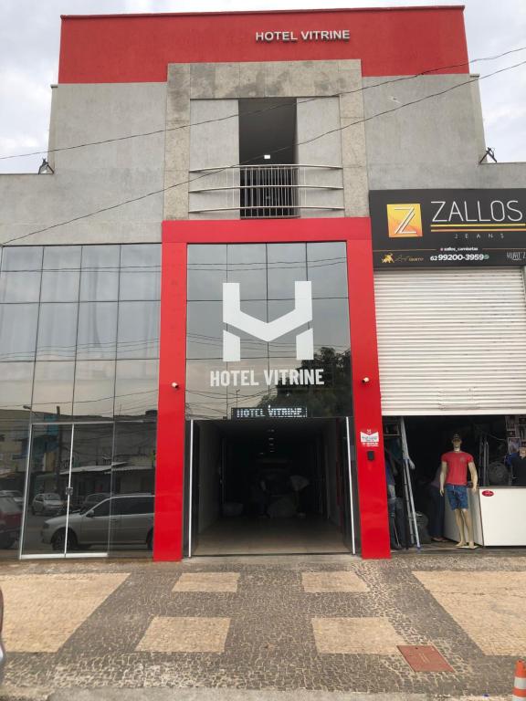 a hotel building with a red door with a hotel sign at Hotel Vitrine in Goiânia