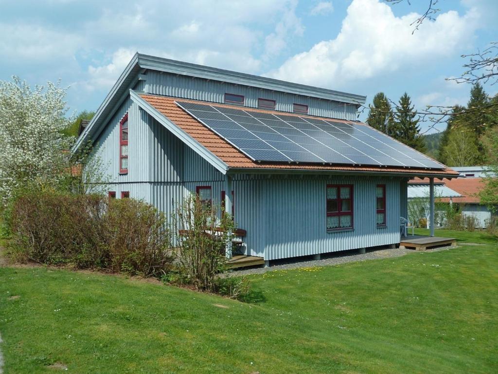una casa con paneles solares en el techo en Ferienhaus Nr 7B2, Feriendorf Hagbügerl, Bayr Wald, en Waldmünchen