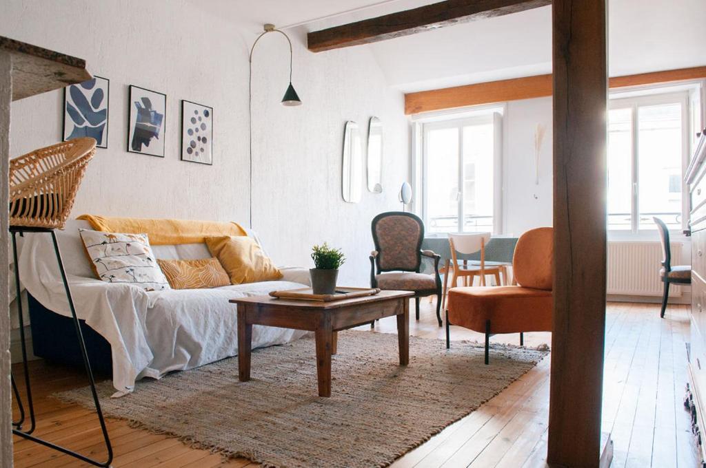 a living room with a couch and a table at Le Pommeraye : Duplex hyper centre in Nantes