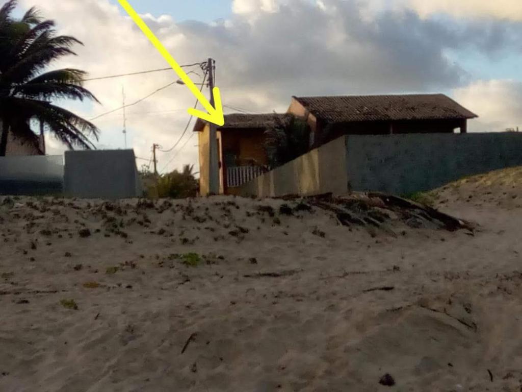 a house on the beach with a yellow arrow at DUPLEX BEIRA MAR TABATINGA in Nísia Floresta