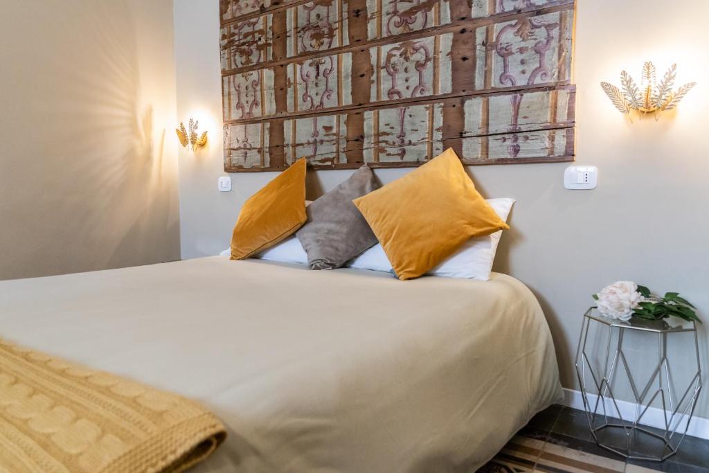 1 dormitorio con 1 cama grande con almohadas amarillas en TRESCA CHARME luxury Rooms, en Bari
