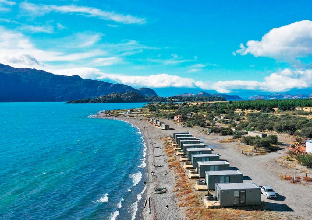 uma praia com um monte de cadeiras na água em Chelenko Lodge em Puerto Tranquilo