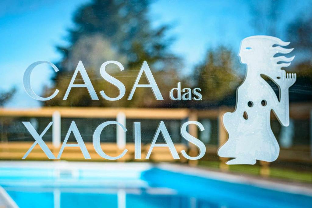 una ventana de cristal con un cartel que diga Casa dos x mas en Casa das xacias ribeira sacra, en A Airoa