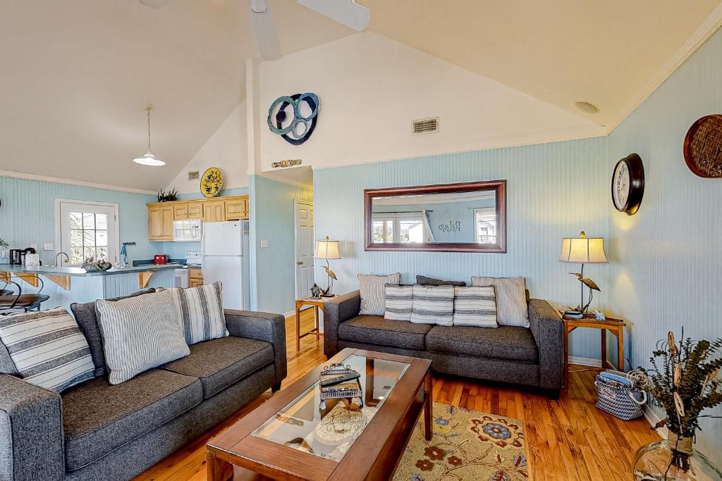 a living room with two couches and a table at Pelican Perch in Dauphin Island