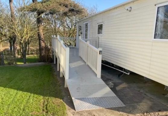 a mobile home with a staircase leading to a house at Emma's Escape accessible caravan at Durdle Door in West Lulworth