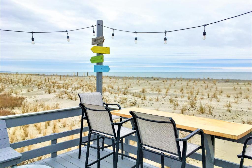 - une table et des chaises sur une terrasse avec vue sur la plage dans l'établissement The Ocean Rose, à Île au chêne