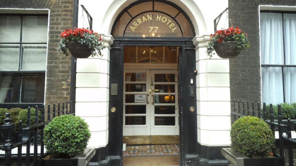 una puerta delantera de un hotel con flores. en Arran House Hotel en Londres