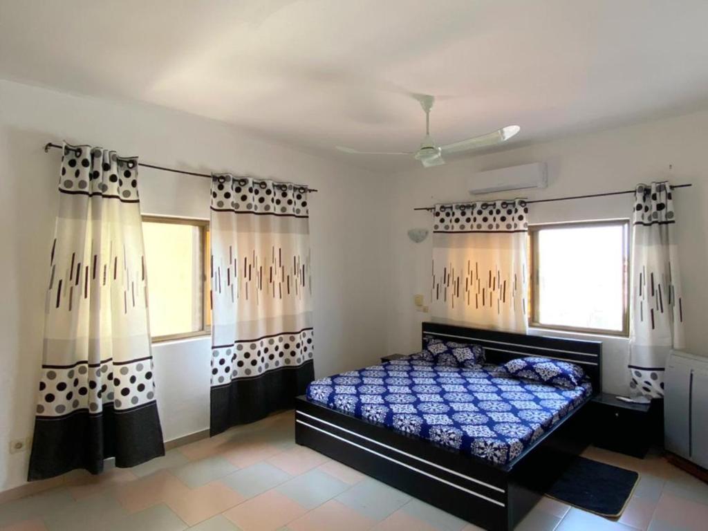 a bedroom with a bed in a room with curtains at Romo appart 1 in Cotonou