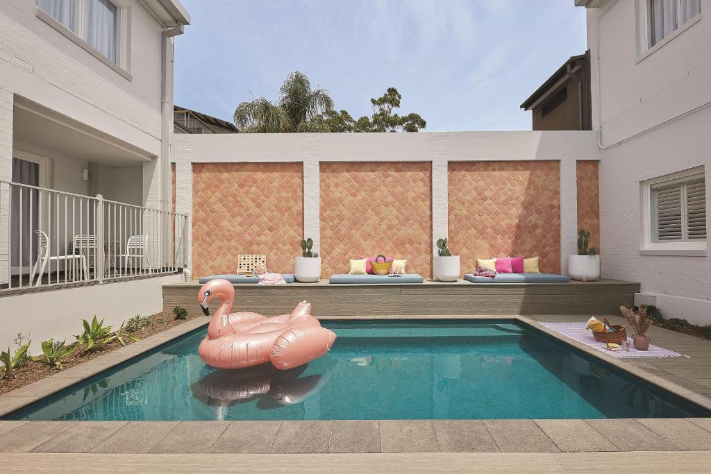 a swimming pool with a pink inflatable flamingo in a house at Adina Apartment Hotel Chippendale in Sydney