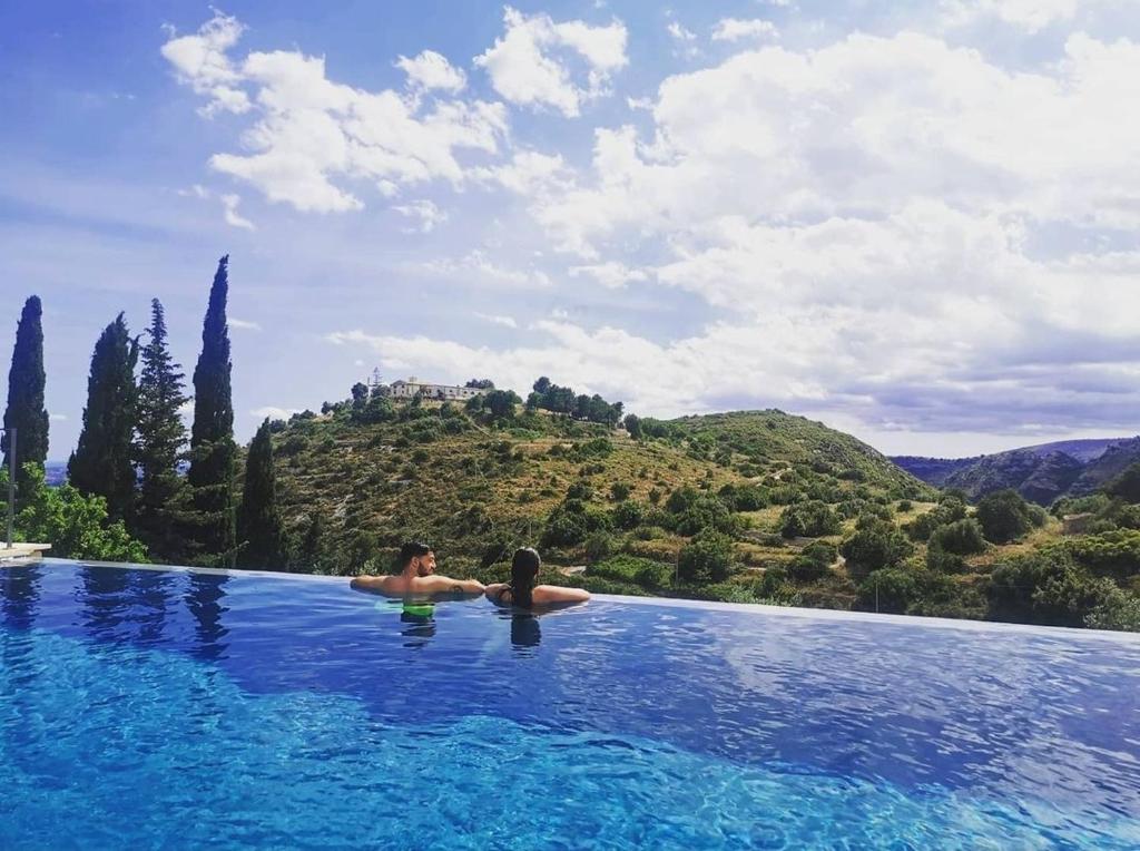 a man and a woman in a swimming pool at Casa Del Mandorlo in Noto