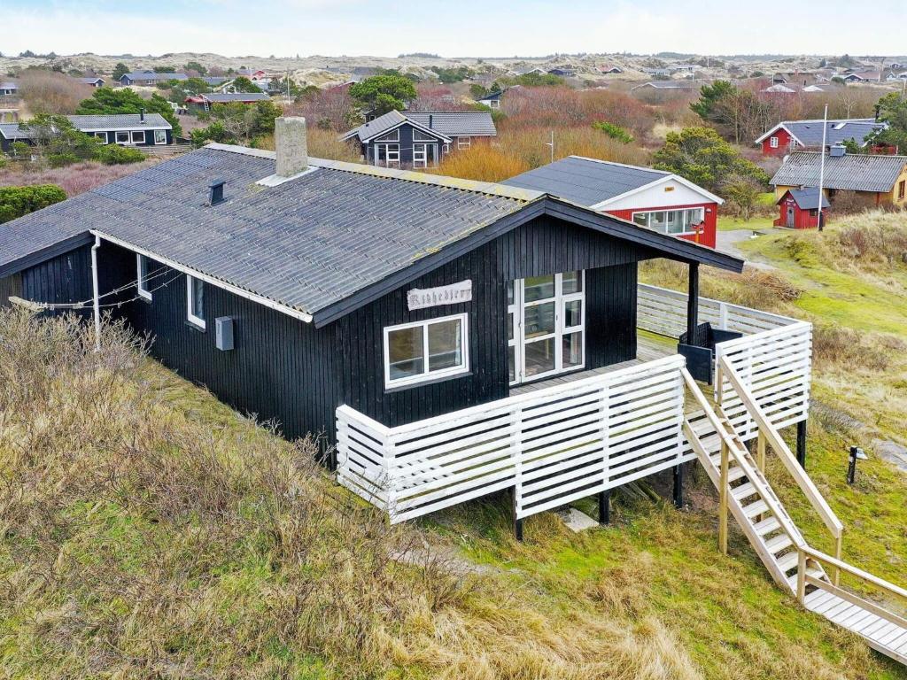 ein schwarzes und weißes Haus auf einem Hügel in der Unterkunft Holiday home Fanø CCIII in Fanø