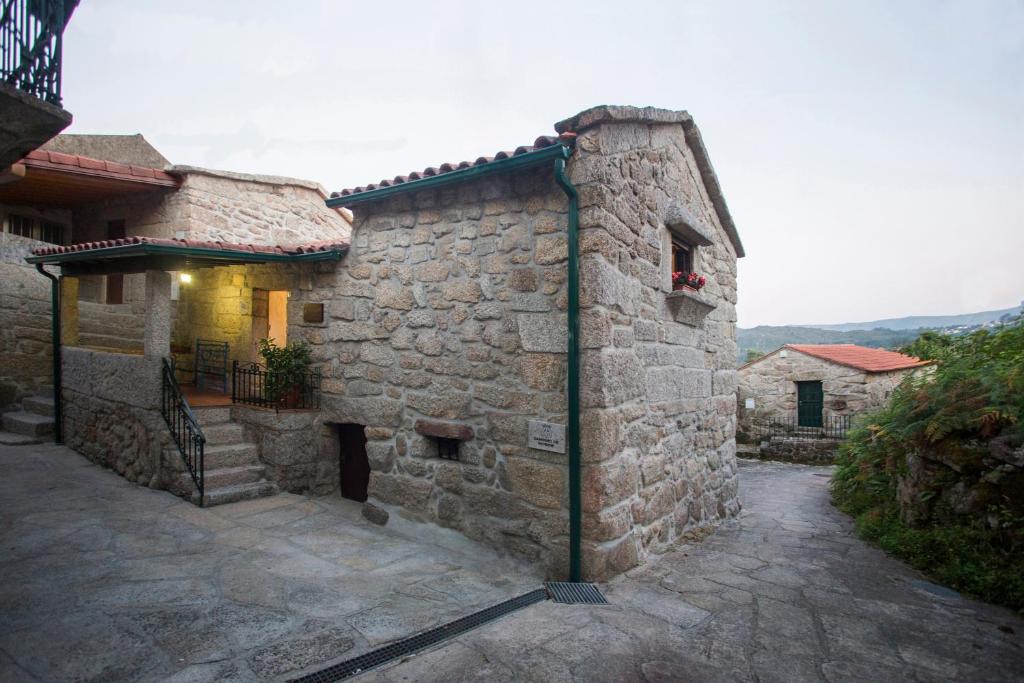 un antiguo edificio de piedra con una puerta lateral en Casa de Ribô en Soajo