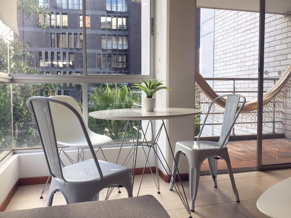 a table and chairs in a room with a window at Moderno apartamento Poblado 10 min del Lleras y Provenza in Medellín