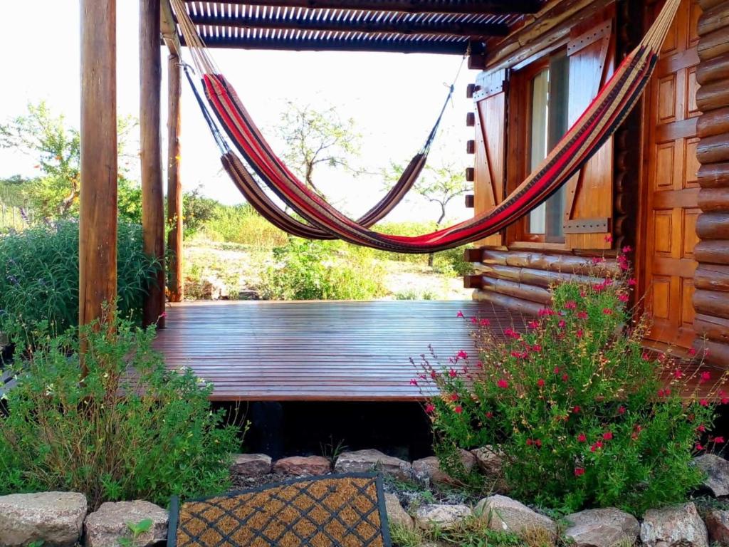 a hammock hanging from a porch of a cabin at Monte Sion cabañas & relax in San Javier