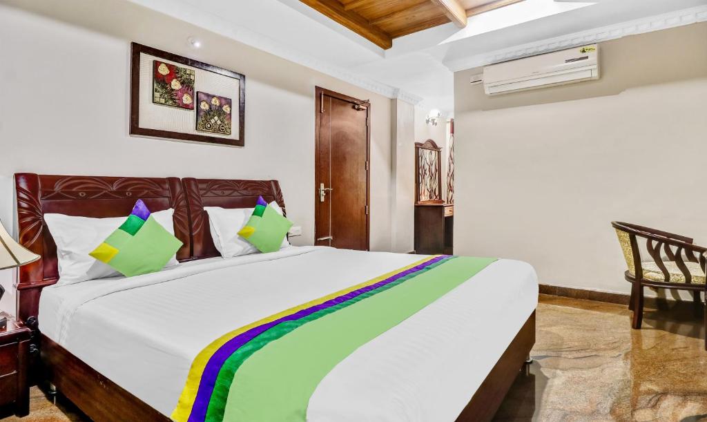 a bedroom with a large white bed with colorful pillows at Treebo Trend Symphony Hotels And Resorts Angamally in Kizhake Chālakudi