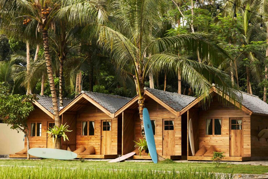 a resort with surfboards in front of it with palm trees at House of Sawah in Batukaras