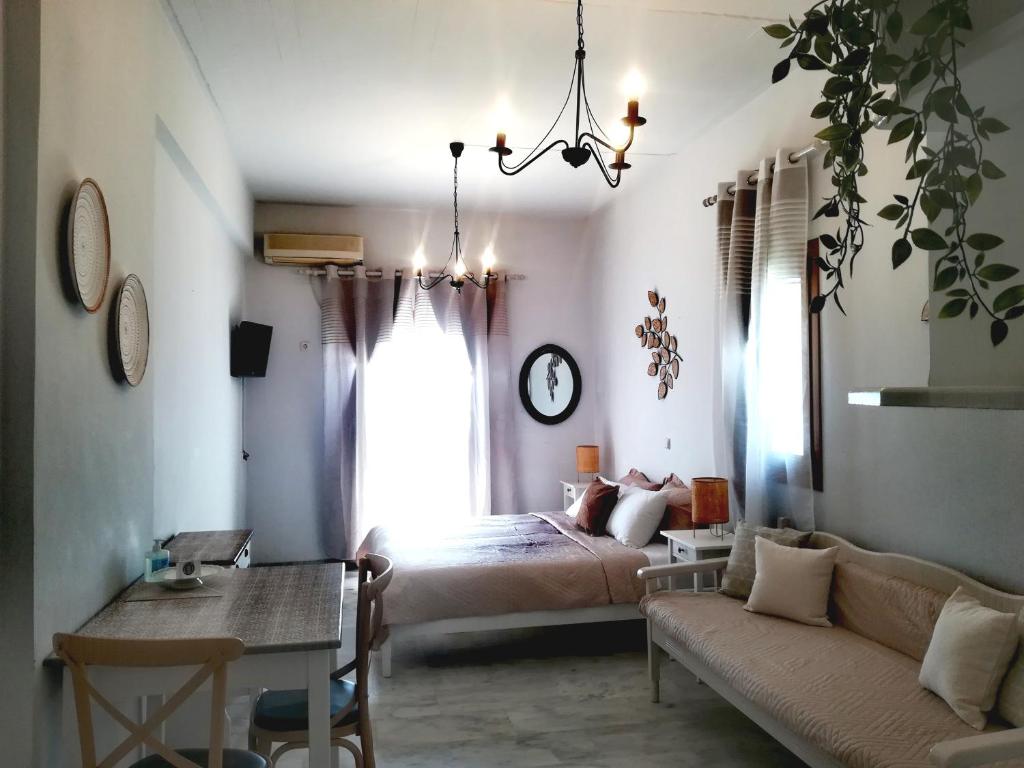 a bedroom with a bed and a couch and a table at Idomeneas Apartments in Sougia