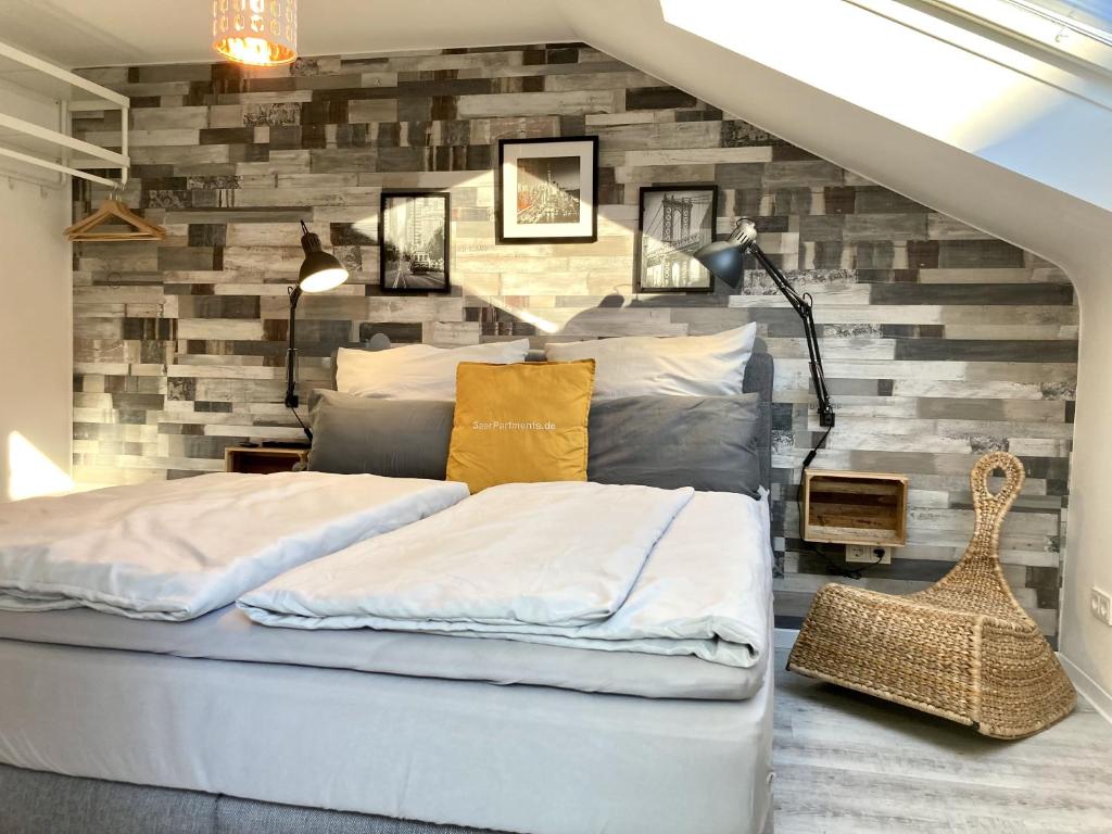 1 Schlafzimmer mit 2 Betten an einer Backsteinwand in der Unterkunft Living at Saarpartments - AdultsOnly - Business & Holiday Homes with Kitchen for Long- and Short Term stay, 3 min to St Johanner Markt and Points of Interest in Saarbrücken