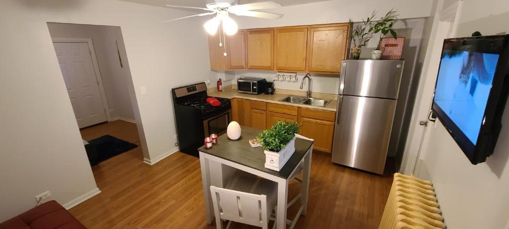 a kitchen with a stainless steel refrigerator and a table at Cozy 1 bedroom, 1 min from Irving Park Blue line, free parking in Chicago