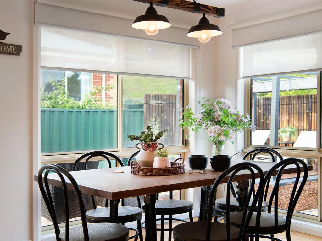 uma sala de jantar com uma mesa de madeira e cadeiras em Wayfarer Cottage em Daylesford