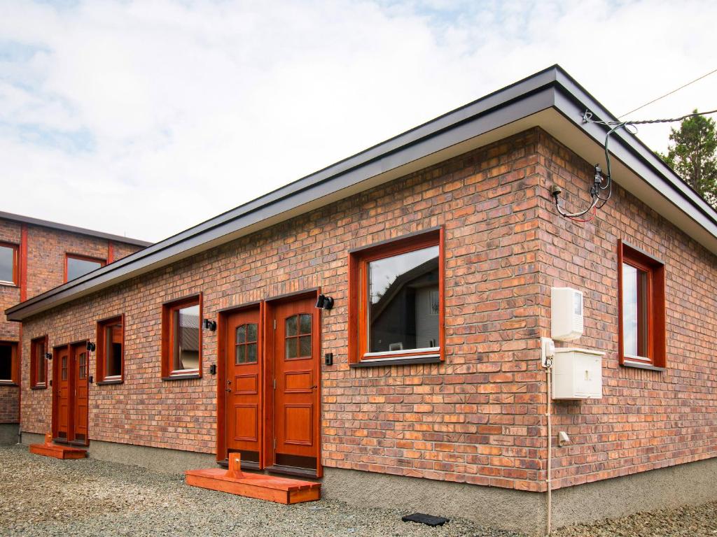 a brick building with brown doors and windows at Brick House Furano in Furano
