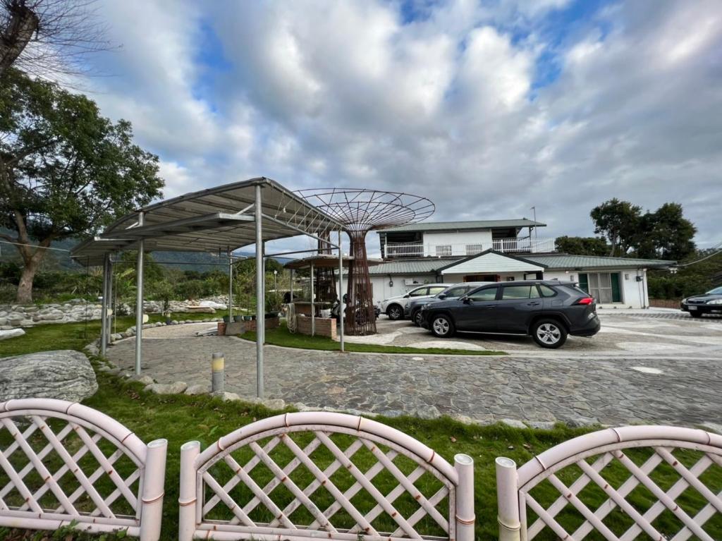 un coche aparcado en un aparcamiento con dos sillas en 樂樂茶民宿, en Yung-an-ts'un