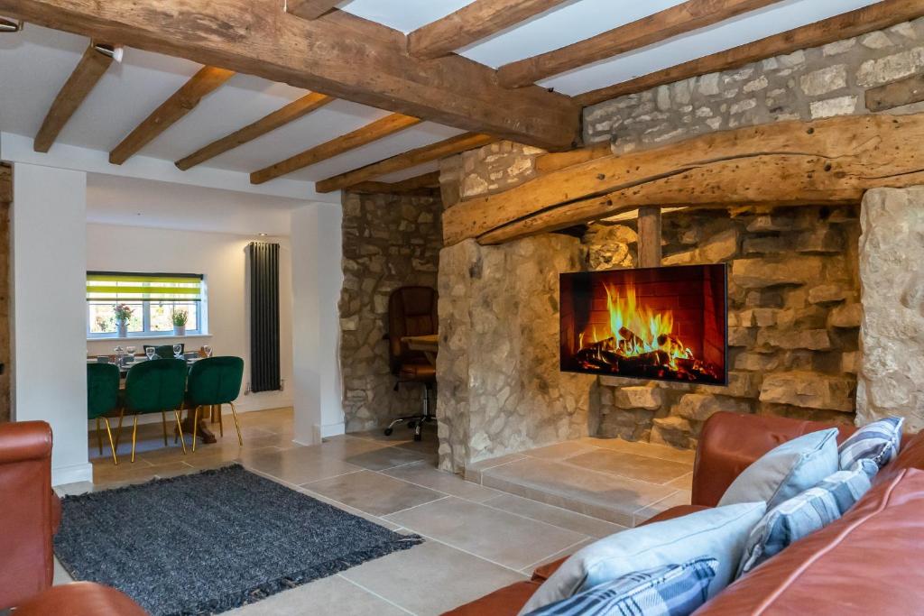 a living room with a large stone fireplace at Stunning 4 Bedroom Cottage-Sleeps 8-Free Parking in Gloucester