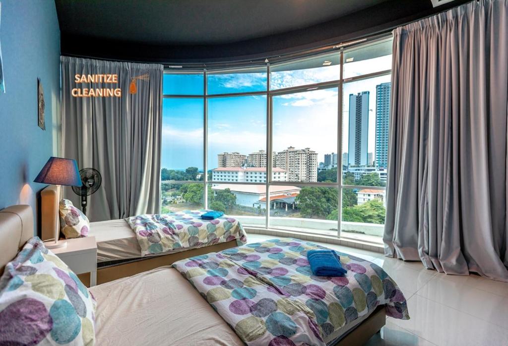 een slaapkamer met 2 bedden en een groot raam bij Cozy Home with Spectacular View in Bayan Lepas