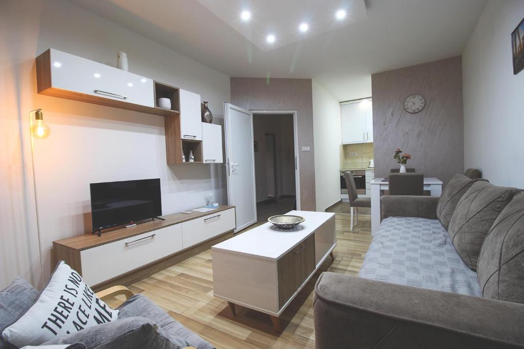 a living room with a couch and a tv at TOP Apartman in Šabac
