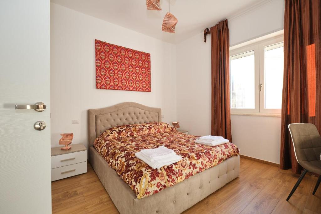 a bedroom with a bed and a chair and windows at Piovella in Cagliari