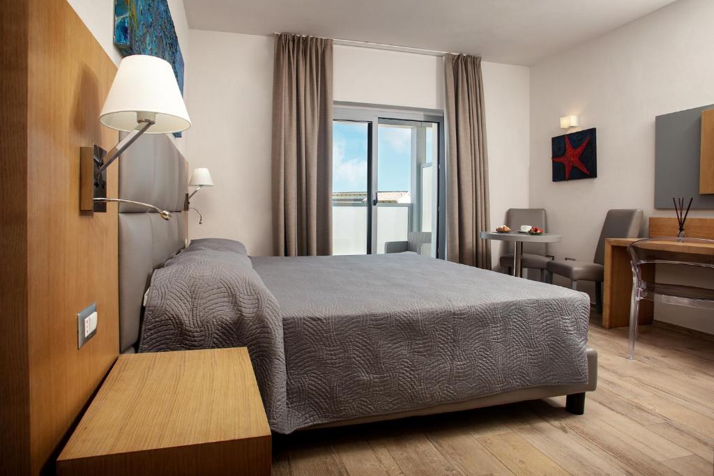 מיטה או מיטות בחדר ב-Capotesta Luxury Rooms