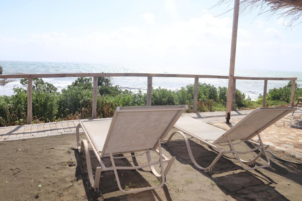 a pair of chairs sitting on a porch overlooking the ocean at Summer Dream Cyprus in Maroni