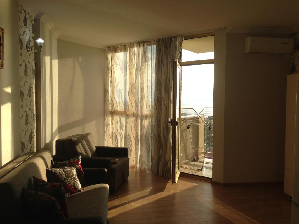 sala de estar con sofá y puerta corredera de cristal en Kobaladze Apartments, en Batumi