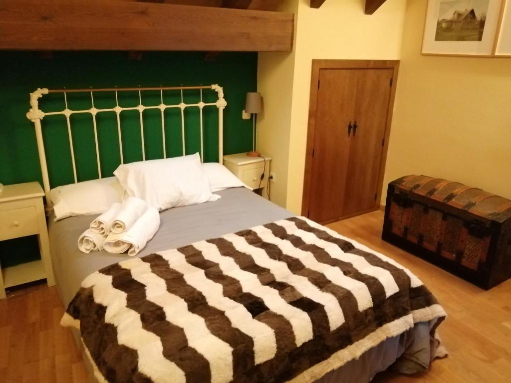 a bedroom with a large bed with towels on it at Caballito de Madera in Pelegrina