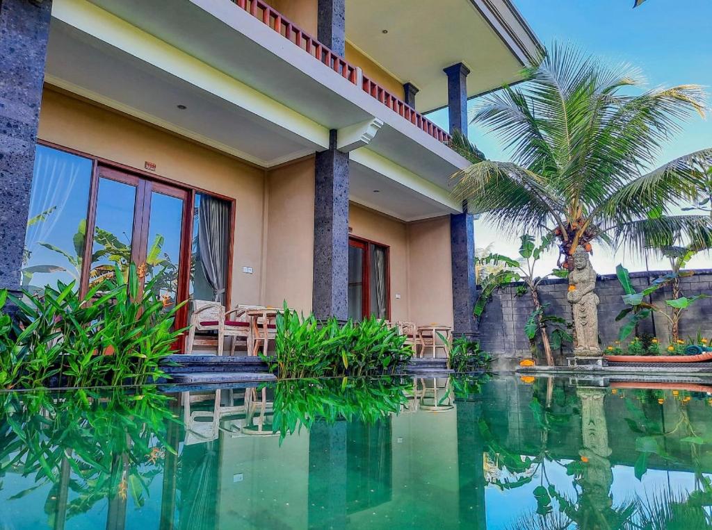 a house with a swimming pool in front of it at Pulu Sari Suite Ubud in Ubud